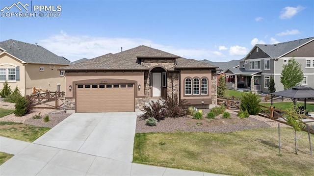 6949 Compass Bend Dr, Colorado Springs, CO 80927 - view of front of property featuring stone siding, a garage, driveway, and stucco siding