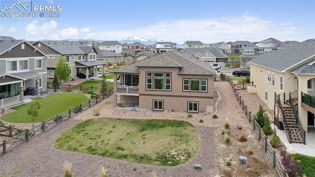 6949 Compass Bend Dr, Colorado Springs, CO 80927 - back of house featuring a residential view, stucco siding, a fenced backyard, and stairway