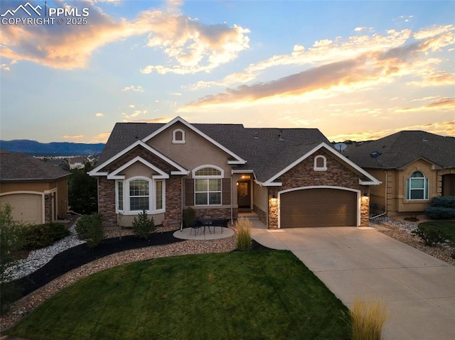 444 Pasada Way, Monument, CO 80132 - view of front of property featuring stone siding, an attached garage, driveway, and a front yard
