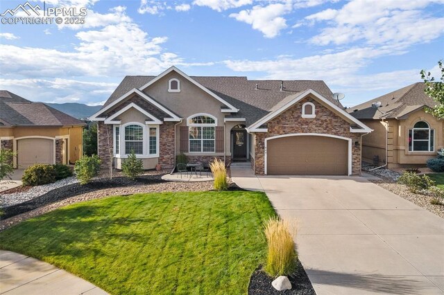 444 Pasada Way, Monument, CO 80132 - view of front of property with driveway, an attached garage, stone siding, and stucco siding