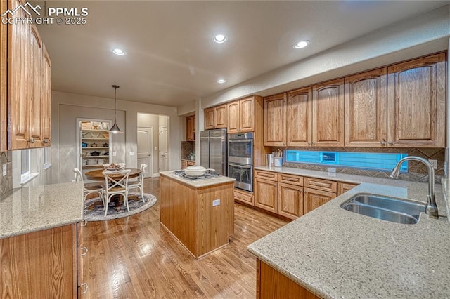 15872 Maple Hill Rd, Monument, CO 80132 - kitchen featuring stainless steel appliances, light stone countertops, light wood-style flooring, a kitchen island, and recessed lighting