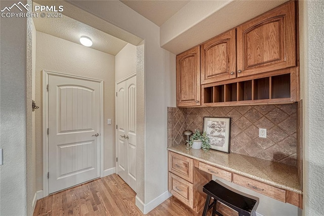 15872 Maple Hill Rd, Monument, CO 80132 - unfurnished office with light wood finished floors, a textured wall, and built in study area