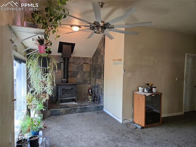 46 Sunflower Rd, Colorado Springs, CO 80907 - unfurnished living room featuring carpet, a wood stove, a ceiling fan, lofted ceiling, and baseboards