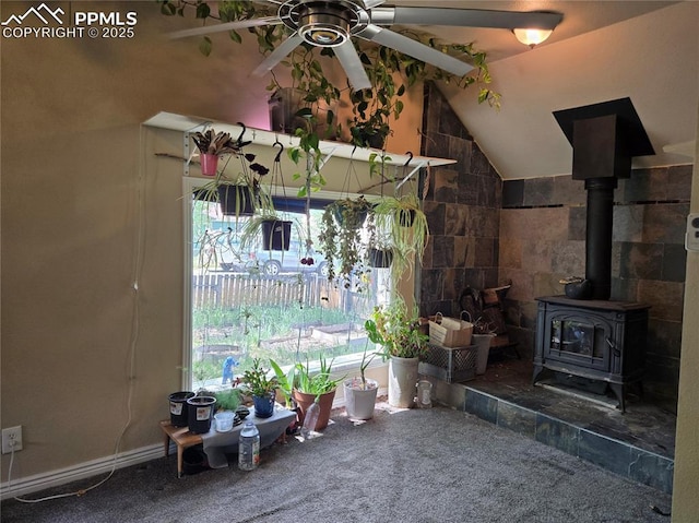46 Sunflower Rd, Colorado Springs, CO 80907 - carpeted living area featuring ceiling fan, vaulted ceiling, and a wood stove
