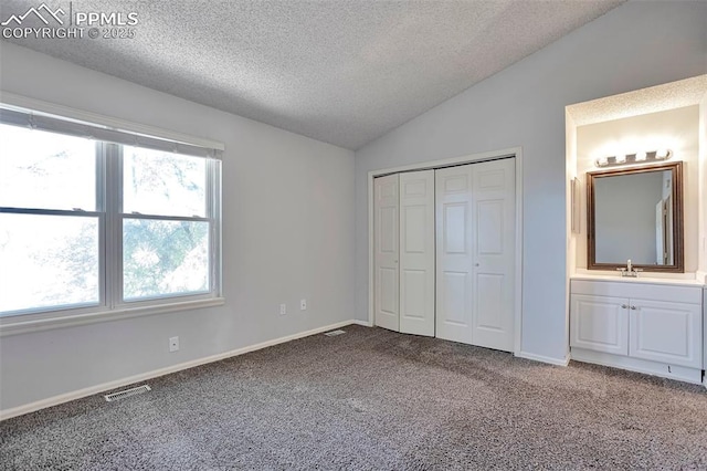 514 Shady Crest Cir, Colorado Springs, CO 80916 - unfurnished bedroom featuring a textured ceiling, vaulted ceiling, carpet, a sink, and a closet
