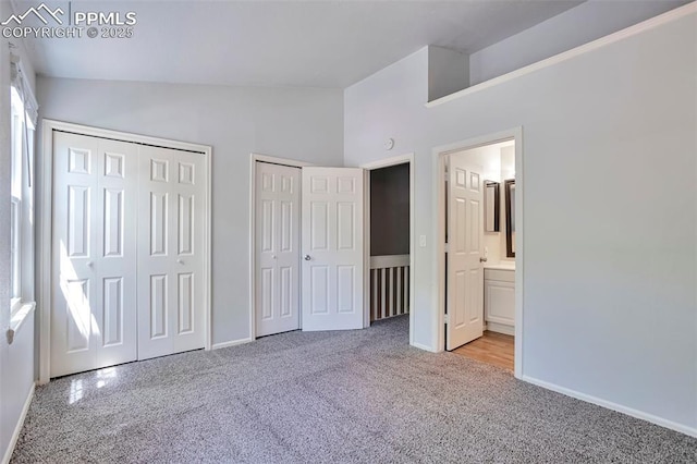 514 Shady Crest Cir, Colorado Springs, CO 80916 - unfurnished bedroom with multiple closets, vaulted ceiling, light colored carpet, baseboards, and connected bathroom