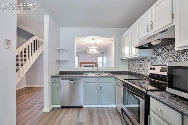 514 Shady Crest Cir, Colorado Springs, CO 80916 - kitchen with stainless steel appliances, under cabinet range hood, a sink, dark countertops, and light wood-style floors