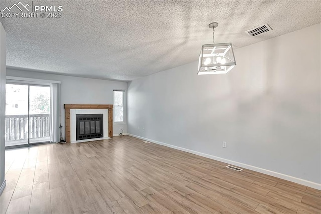514 Shady Crest Cir, Colorado Springs, CO 80916 - unfurnished living room featuring a textured ceiling, wood finished floors, baseboards, and a fireplace with flush hearth