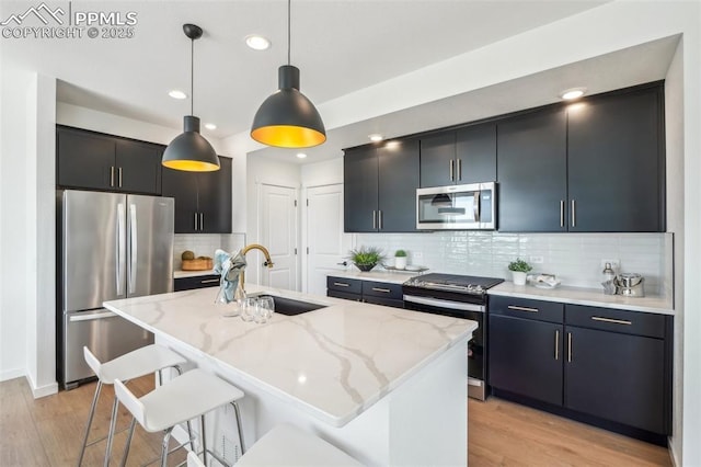 6913 Knapp Dr, Colorado Springs, CO 80924 - kitchen with appliances with stainless steel finishes, a sink, hanging light fixtures, dark cabinetry, and recessed lighting