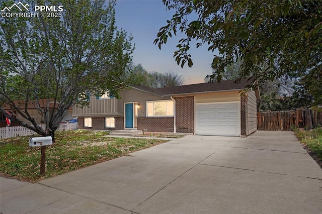 3712 Encino St, Colorado Springs, CO 80918 - tri-level home with a garage, brick siding, and driveway