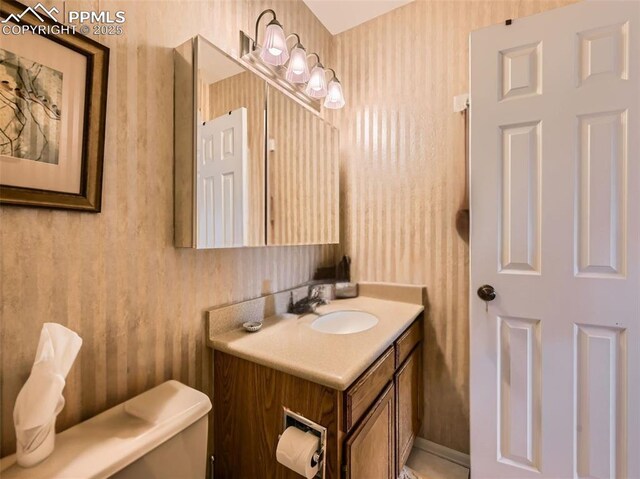 2186 Giltshire Dr, Colorado Springs, CO 80905 - half bathroom with toilet, vanity, and wallpapered walls