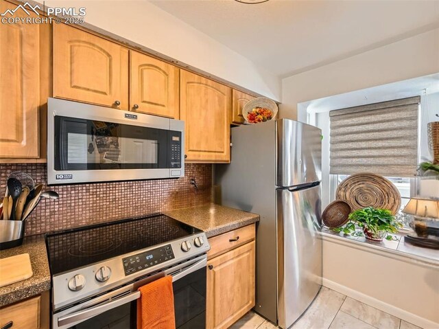 2186 Giltshire Dr, Colorado Springs, CO 80905 - kitchen featuring stainless steel appliances, backsplash, dark countertops, light tile patterned floors, and light brown cabinets