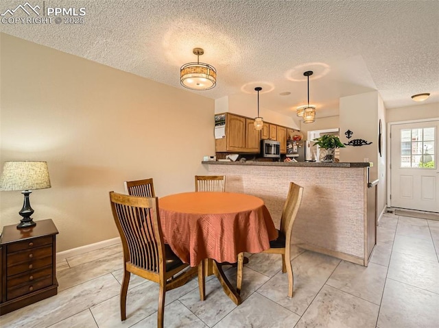 2186 Giltshire Dr, Colorado Springs, CO 80905 - dining area featuring a textured ceiling, light tile patterned floors, and baseboards