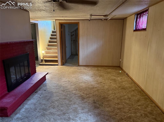 2531 Gunnison St, Colorado Springs, CO 80909 - unfurnished living room with a brick fireplace, carpet, stairs, wooden walls, and a textured ceiling
