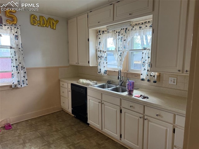2531 Gunnison St, Colorado Springs, CO 80909 - kitchen with black dishwasher, a sink, baseboards, light countertops, and white cabinets