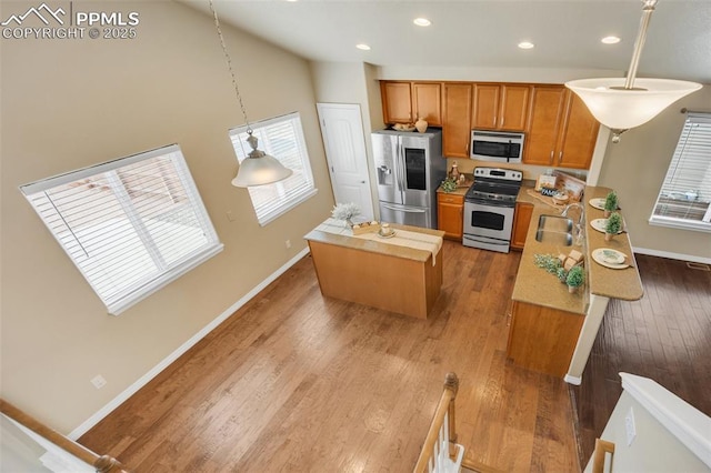 6259 Bearcat Loop, Colorado Springs, CO 80925 - kitchen with stainless steel appliances, brown cabinetry, baseboards, recessed lighting, and a kitchen island