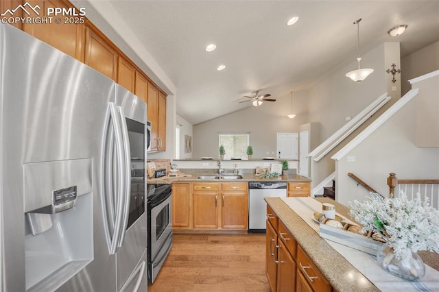 6259 Bearcat Loop, Colorado Springs, CO 80925 - kitchen with appliances with stainless steel finishes, light wood-style flooring, brown cabinetry, vaulted ceiling, and ceiling fan