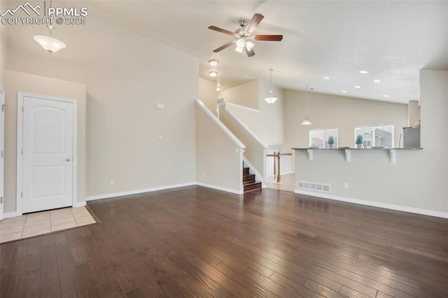 6259 Bearcat Loop, Colorado Springs, CO 80925 - unfurnished living room with a ceiling fan, hardwood / wood-style floors, vaulted ceiling, stairway, and baseboards