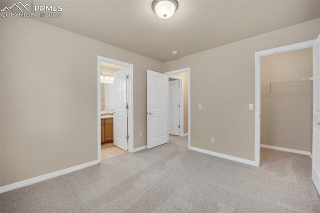 6259 Bearcat Loop, Colorado Springs, CO 80925 - unfurnished bedroom featuring a walk in closet, light carpet, baseboards, and a closet