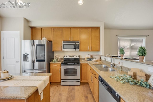 6259 Bearcat Loop, Colorado Springs, CO 80925 - kitchen featuring stainless steel appliances, a sink, light wood-style floors, light stone countertops, and recessed lighting