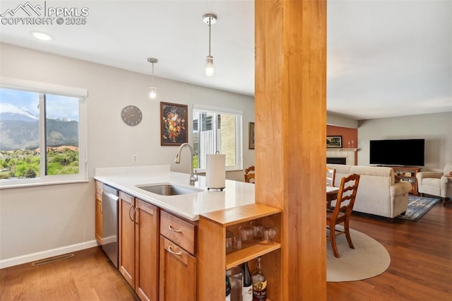 954 Fontmore Rd Unit B, Colorado Springs, CO 80904 - kitchen with a sink, dishwasher, dark wood finished floors, a tile fireplace, and brown cabinetry
