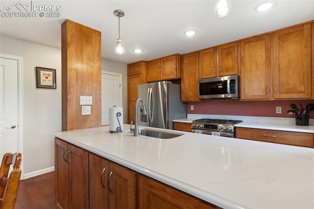 954 Fontmore Rd Unit B, Colorado Springs, CO 80904 - kitchen with stainless steel appliances, a sink, brown cabinets, dark wood finished floors, and decorative light fixtures