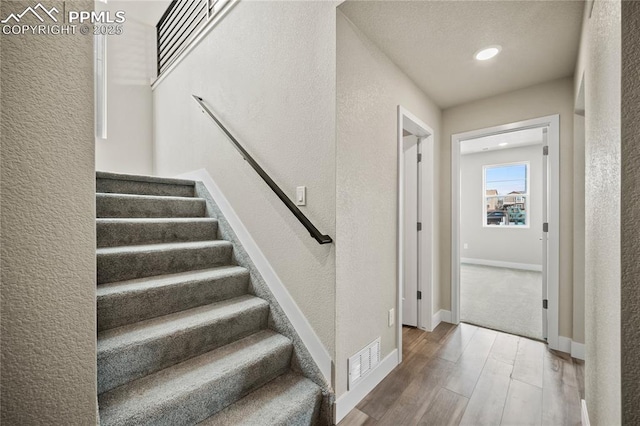 3065 Curly Grv, Colorado Springs, CO 80922 - staircase featuring wood finished floors, a textured wall, recessed lighting, and baseboards