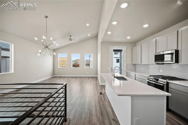 3065 Curly Grv, Colorado Springs, CO 80922 - kitchen with stainless steel appliances, a sink, wood finished floors, open floor plan, and a chandelier