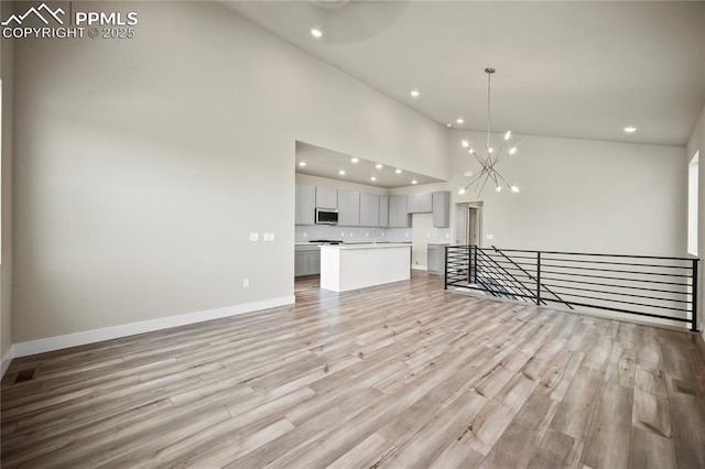 3065 Curly Grv, Colorado Springs, CO 80922 - unfurnished living room featuring high vaulted ceiling, recessed lighting, a chandelier, baseboards, and light wood-style floors