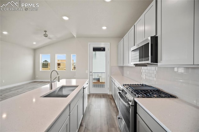 3065 Curly Grv, Colorado Springs, CO 80922 - kitchen with appliances with stainless steel finishes, a sink, light wood finished floors, backsplash, and recessed lighting