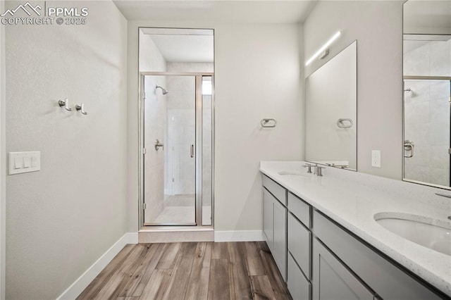 3065 Curly Grv, Colorado Springs, CO 80922 - full bath with a stall shower, baseboards, wood finished floors, and double vanity