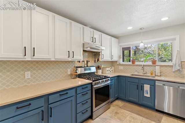 1107 Parkview Blvd, Colorado Springs, CO 80905 - kitchen with stainless steel appliances, under cabinet range hood, a sink, blue cabinets, and white cabinets