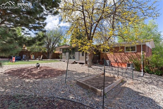 1107 Parkview Blvd, Colorado Springs, CO 80905 - view of front of home featuring a sunroom, brick siding, and a vegetable garden
