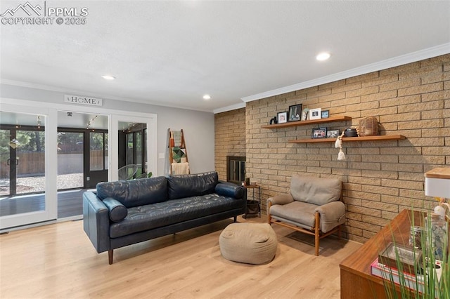 1107 Parkview Blvd, Colorado Springs, CO 80905 - living room with ornamental molding, light wood-style flooring, a brick fireplace, recessed lighting, and brick wall