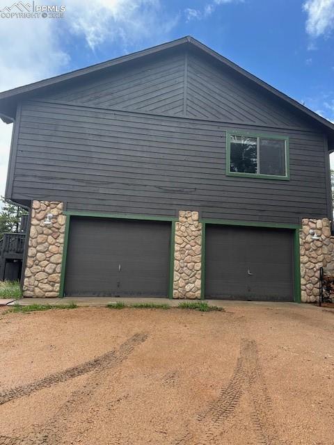 4041 Trout Creek Rd, Woodland Park, CO 80863 - view of side of property featuring stone siding and dirt driveway