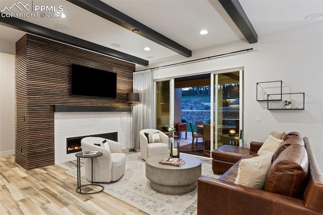 16244 Thunder Cat Way, Monument, CO 80132 - living area featuring beamed ceiling, wood finished floors, a tiled fireplace, baseboards, and recessed lighting