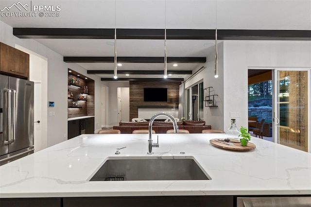 16244 Thunder Cat Way, Monument, CO 80132 - kitchen with open floor plan, high end fridge, a sink, beam ceiling, and light stone counters