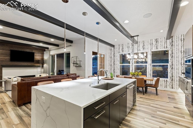 16244 Thunder Cat Way, Monument, CO 80132 - kitchen featuring wallpapered walls, a sink, open floor plan, beamed ceiling, and light wood-style floors