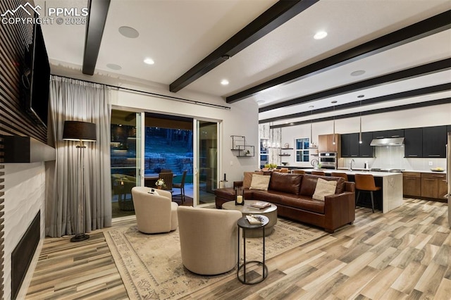 16244 Thunder Cat Way, Monument, CO 80132 - living area featuring light wood-style floors, beam ceiling, a fireplace, and recessed lighting