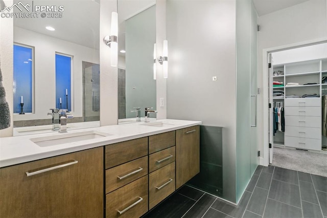 16244 Thunder Cat Way, Monument, CO 80132 - full bathroom featuring double vanity, a walk in closet, tile patterned flooring, tiled shower, and recessed lighting