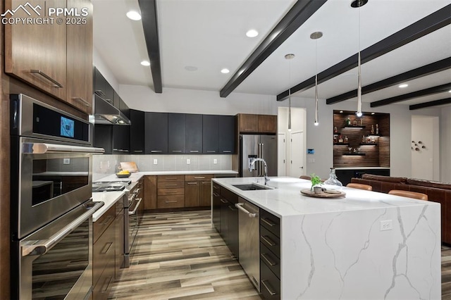 16244 Thunder Cat Way, Monument, CO 80132 - kitchen with appliances with stainless steel finishes, light wood finished floors, a sink, beamed ceiling, and decorative backsplash