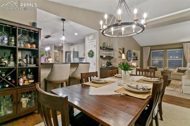 9131 Estebury Cir, Colorado Springs, CO 80920 - dining area with a chandelier, light wood finished floors, and vaulted ceiling
