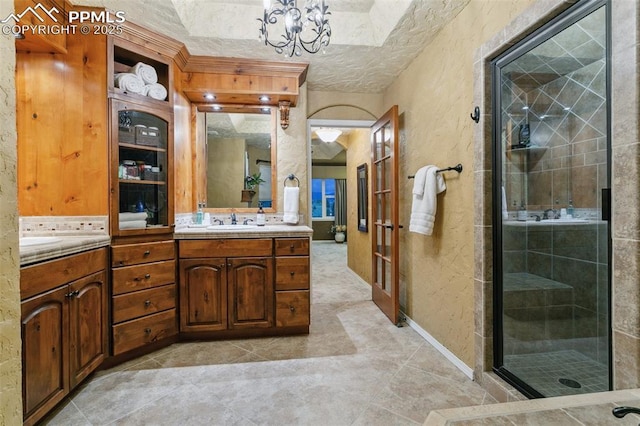 9131 Estebury Cir, Colorado Springs, CO 80920 - bathroom with a textured wall, vanity, french doors, a shower stall, and a chandelier