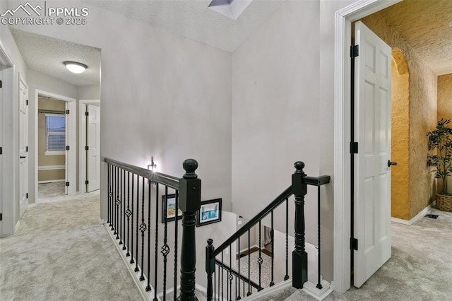 9131 Estebury Cir, Colorado Springs, CO 80920 - hallway featuring an upstairs landing, carpet flooring, a textured ceiling, and baseboards