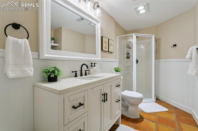 9131 Estebury Cir, Colorado Springs, CO 80920 - full bath with wainscoting, a stall shower, toilet, vanity, and tile patterned floors