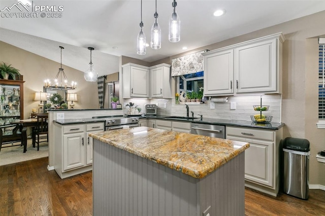 9131 Estebury Cir, Colorado Springs, CO 80920 - kitchen with a sink, stainless steel appliances, a peninsula, tasteful backsplash, and vaulted ceiling