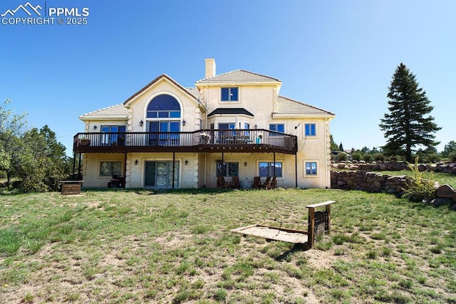 1120 Brenthaven Ct, Monument, CO 80132 - back of house with a chimney, a deck, a yard, a tile roof, and stucco siding