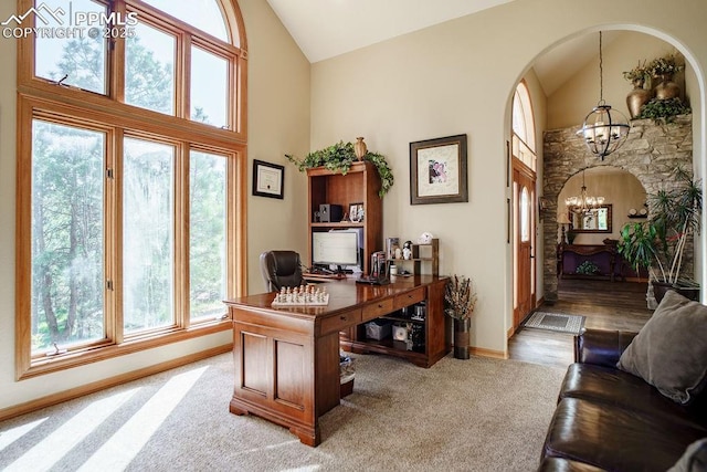 1120 Brenthaven Ct, Monument, CO 80132 - home office featuring a chandelier, high vaulted ceiling, light carpet, baseboards, and arched walkways