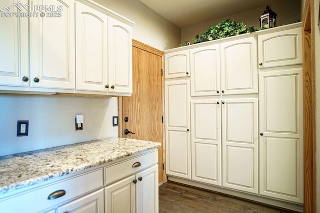 1120 Brenthaven Ct, Monument, CO 80132 - kitchen with light stone counters, dark wood-type flooring, and white cabinets