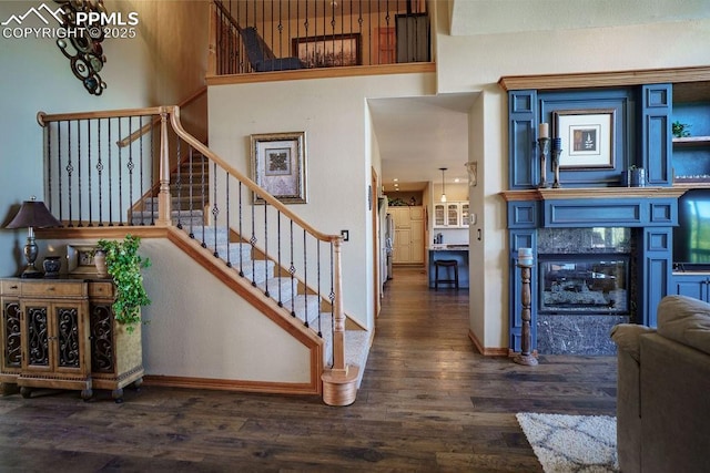1120 Brenthaven Ct, Monument, CO 80132 - stairway featuring wood finished floors, baseboards, and a glass covered fireplace